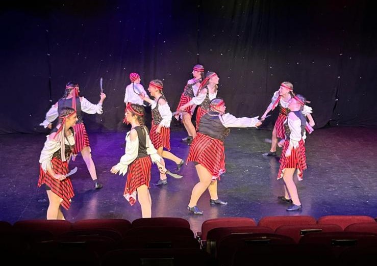 Ballet performance with graceful arm positions and lighting effects